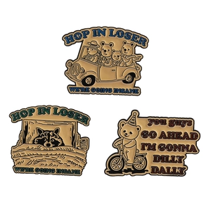 Trois broches en émail représentant des ours conduisant et à vélo sur un fond blanc neutre