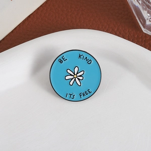 Broche fleur minimaliste en émail bleu ciel avec marguerite blanche et slogan Be Kind