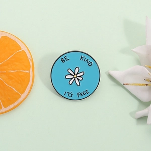 Blue enamel daisy brooch with BE KIND IT'S FREE slogan and white flower pattern