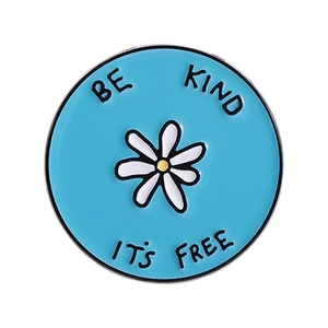 Broche en émail bleu avec marguerite et message Be Kind It's Free sur fond blanc neutre