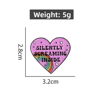 Detailed view of pink heart enamel pin with rainbow and Silently Screaming Inside text