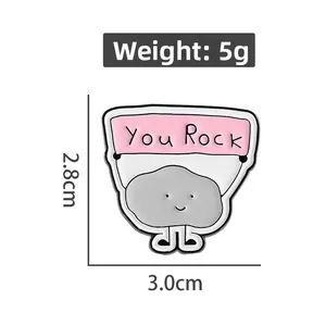 Detail showing 'You Rock' enamel pin dimensions 2.8cm by 3.0cm with 5g weight data