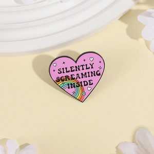Pink heart enamel pin with Silently Screaming Inside text and rainbow detail