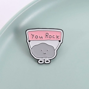 Cute cartoon rock enamel pin holding a pink You Rock banner for clothing decoration