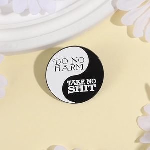 Détail du pin's émaillé Yin-Yang avec texte Do No Harm sur fond floral