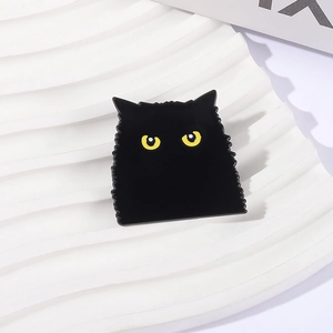 Spilla in smalto gatto nero carino con occhi gialli su sfondo bianco decorativo