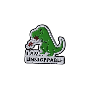 Cartoon green T-Rex dinosaur enamel pin with I Am Unstoppable text for backpacks