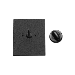 Detail of matte black metal brooch pin back with secure butterfly clutch fastener