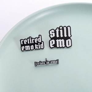 Set di tre spille Still Emo in smalto bianco e nero su un piatto di ceramica