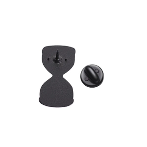 Detailed back view of an enamel pin with black rubber clutch and metallic pin back