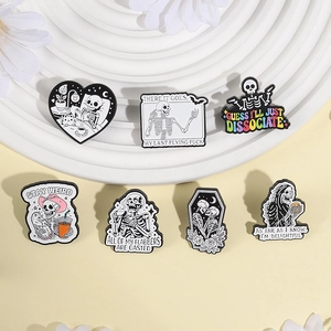 Set of 7 skull enamel pins with humorous quotes on a white tray for Halloween