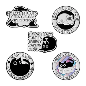 Set of five cute black cat enamel pins with humorous quotes on white background