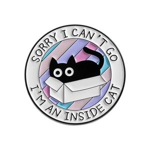 Round enamel pin featuring a black cat in a box with Inside Cat text decoration