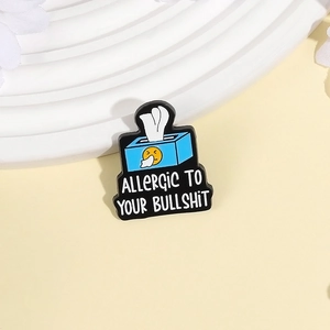 Cartoon blue tissue box enamel pin with Allergic To Your Bullshit text on a stand