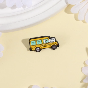 Dettaglio della spilla smaltata bus giallo con anatra e citazione Get in Bestie divertente