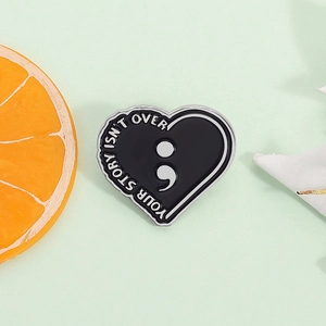 Pin's cœur en émail noir avec message your story isn't over et symbole point-virgule