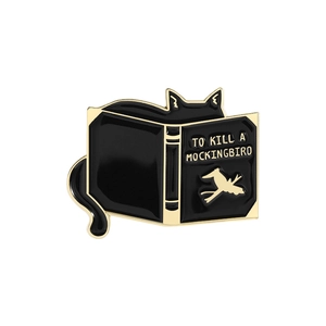 Enamel black cat pin peeking behind To Kill a Mockingbird book with gold plating