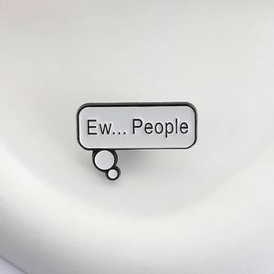 Macro detail of enamel pin with 'Ew... People' text and conversation bubble design