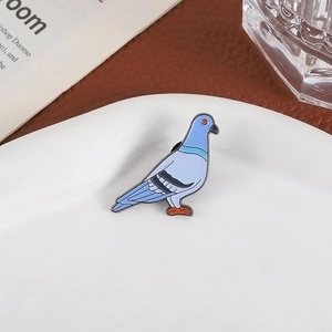 Niedliche Cartoon blaue Taube Emaille Brosche Pin auf einem weißen Keramikteller