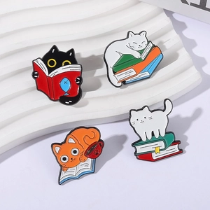 Cartoon enamel pins set featuring adorable cats reading books on a textured white tray