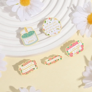 Five-piece floral enamel pin set with motivational quotes on a white display stand