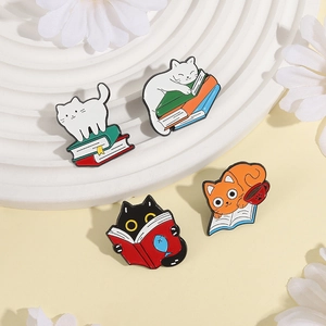 Close-up of four cute cartoon cat enamel pins on books with high-quality metal finish