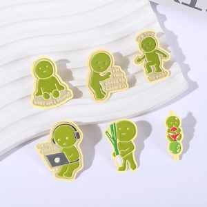 Set of six green cartoon enamel pins in various poses on a white ceramic tray