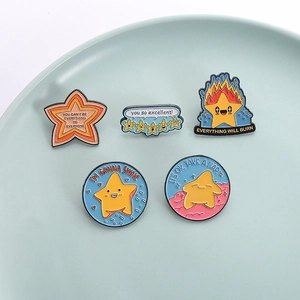 Minimalist enamel star pins with motivational text in a decorative ceramic plate