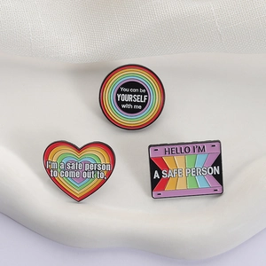 Rainbow enamel brooch set featuring heart and circle pins with inclusive slogans