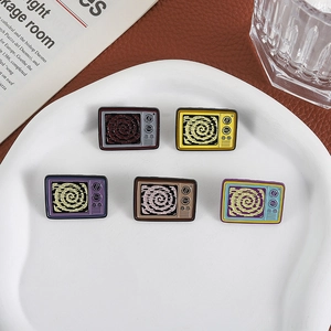 Set of five retro colorful TV enamel pins with spiral patterns on a white tray