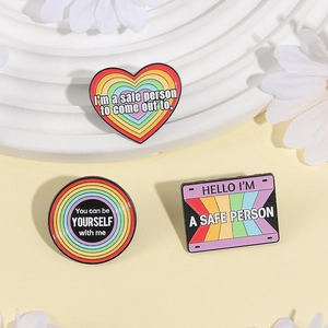 Rainbow heart enamel pins set with supportive slogans on a decorative display stand