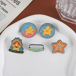 Lot de cinq broches en émail en forme d'étoile avec citations sur une assiette blanche