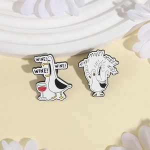 Black and white seagull enamel pins set with Wine and Mine text on wave display stand