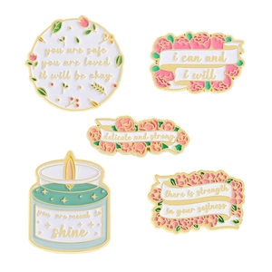 Set of 5 enamel pins featuring flowers and motivational quotes on white background