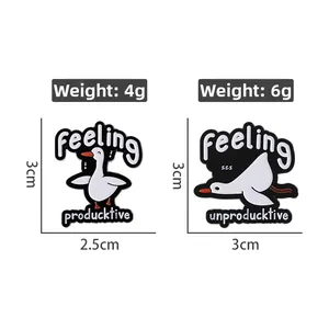 Detailed view of two white cartoon goose enamel pins with playful productive word puns