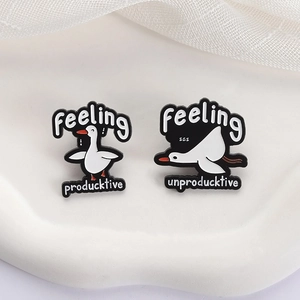 Funny duck enamel pin set with 'Feeling producktive' and 'unproducktive' text on white tray