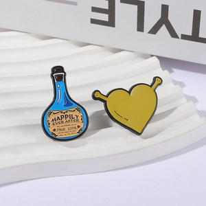 Cartoon monster heart and blue potion enamel pins set on a white textured stand