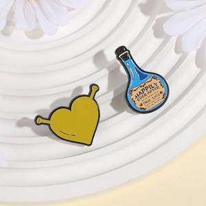 Cartoon Shrek heart enamel pins and blue magic potion bottle brooch on white tray