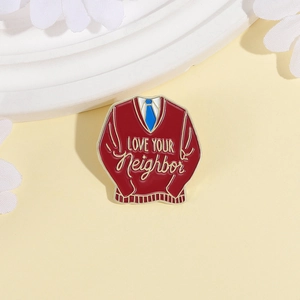 Red V-neck sweater enamel brooch with Love Your Neighbor quote in gold and blue tie