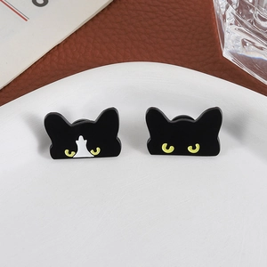 Set of two cute black and white tuxedo cat enamel pins on a white tray with creative decor