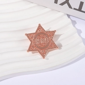 Rose gold sheriff badge brooch with hexagonal star design and ornate floral engraving