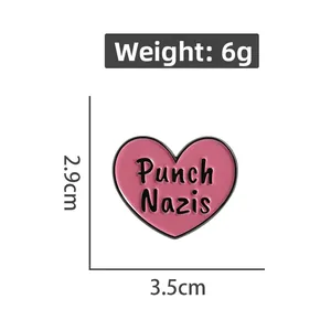 Macro shot of pink heart enamel brooch with Punch Nazis text, size 3.5cm x 2.9cm