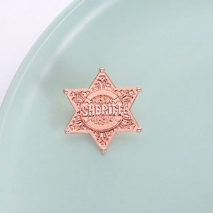 Hexagonal rose gold sheriff star badge with intricate engraving and sheriff text