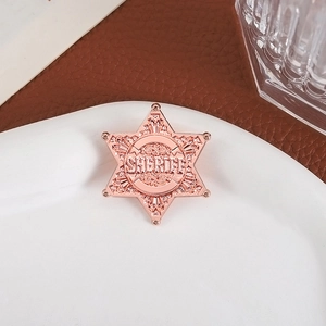 Rose gold sheriff star badge with hexagonal design and fine engraved metallic textures
