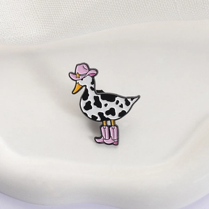 Cute enamel pin featuring a duck in cow print with a pink cowboy hat and boots