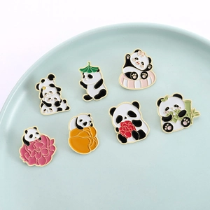 Set of 7 cute panda enamel pins with gold trim featuring various poses on a ceramic dish