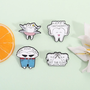 Lot de quatre broches en émail en forme de dents avec des jeux de mots sur fond vert