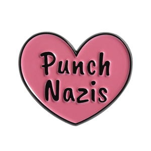 Pink heart enamel pin featuring black metal outline and Punch Nazis text design