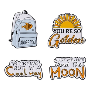 Set of 4 cute enamel pins featuring backpack with goldfish and sun with golden quotes