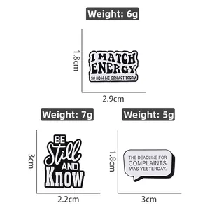 Close-up of minimalist black and white enamel pins with funny English quotes and metal finish